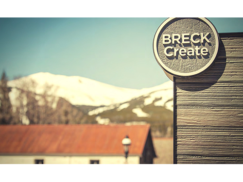 Image of Breckenridge with mountains in the background and a "Breck Create" banner infront.