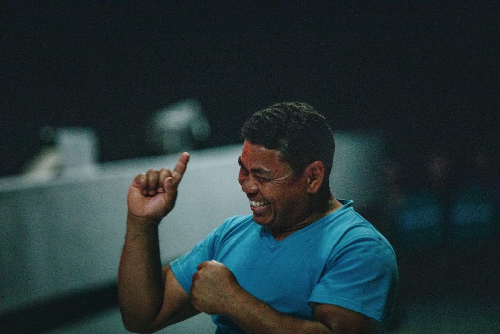 A man in a light blue shirt signing.