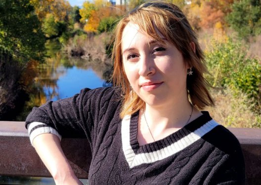 CVSuite Support Coordinator Kelsey Foster standing outside on a bridge posing for the picture.